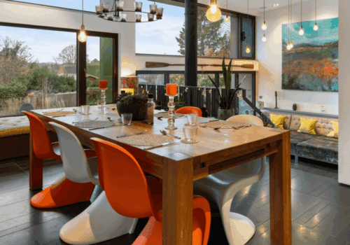A modern, welcoming living and dining space styled by an interior designer, showing layered textures and harmonious furniture placement